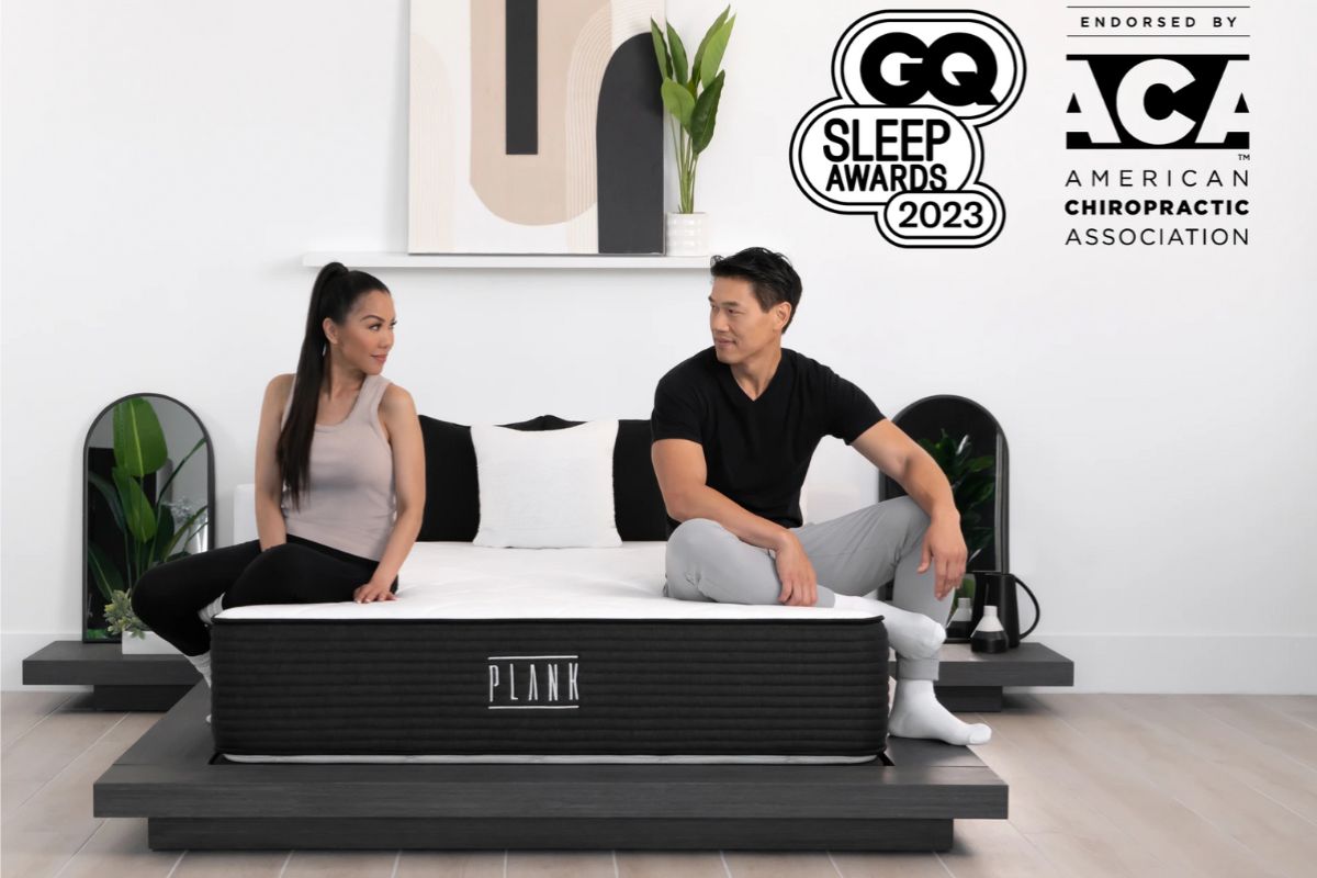 Plank Firm Luxe mattress with couple sitting demonstrating firm support and comfort