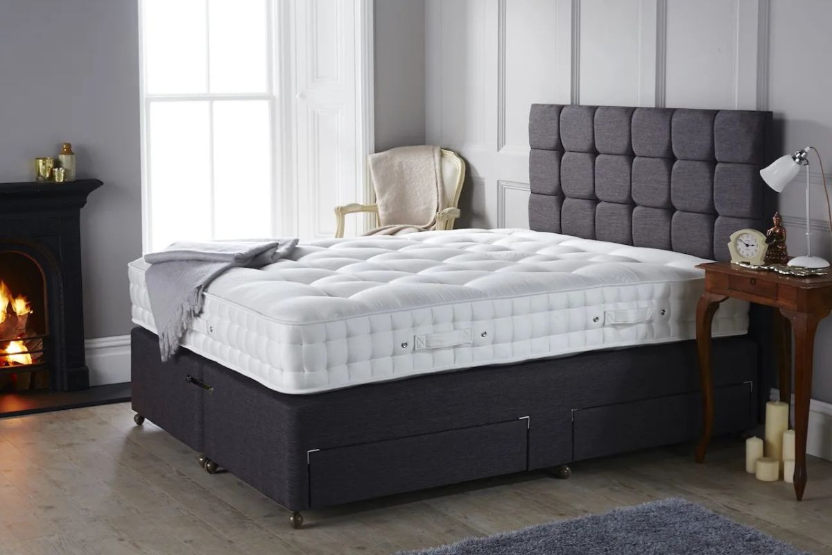 Full size bed with a thick mattress and tall upholstered frame showing overall bed height