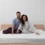 Couple sitting comfortably on a mattress, illustrating the importance of shared comfort and support when choosing the best mattress for couples