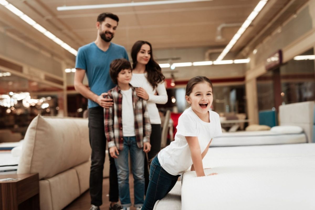 Do Kids Need a Soft or Firm Mattress? Family testing mattresses in a showroom, demonstrating how parents can compare mattress firmness options to find the best fit for a child