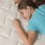 Child sleeping comfortably on a mattress, illustrating the importance of choosing the right mattress firmness for growing kids