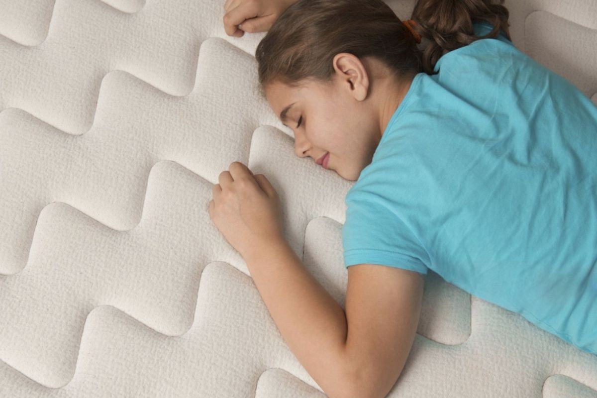 Do Kids Need a Soft or Firm Mattress? Child sleeping comfortably on a mattress, illustrating the importance of choosing the right mattress firmness for growing kids