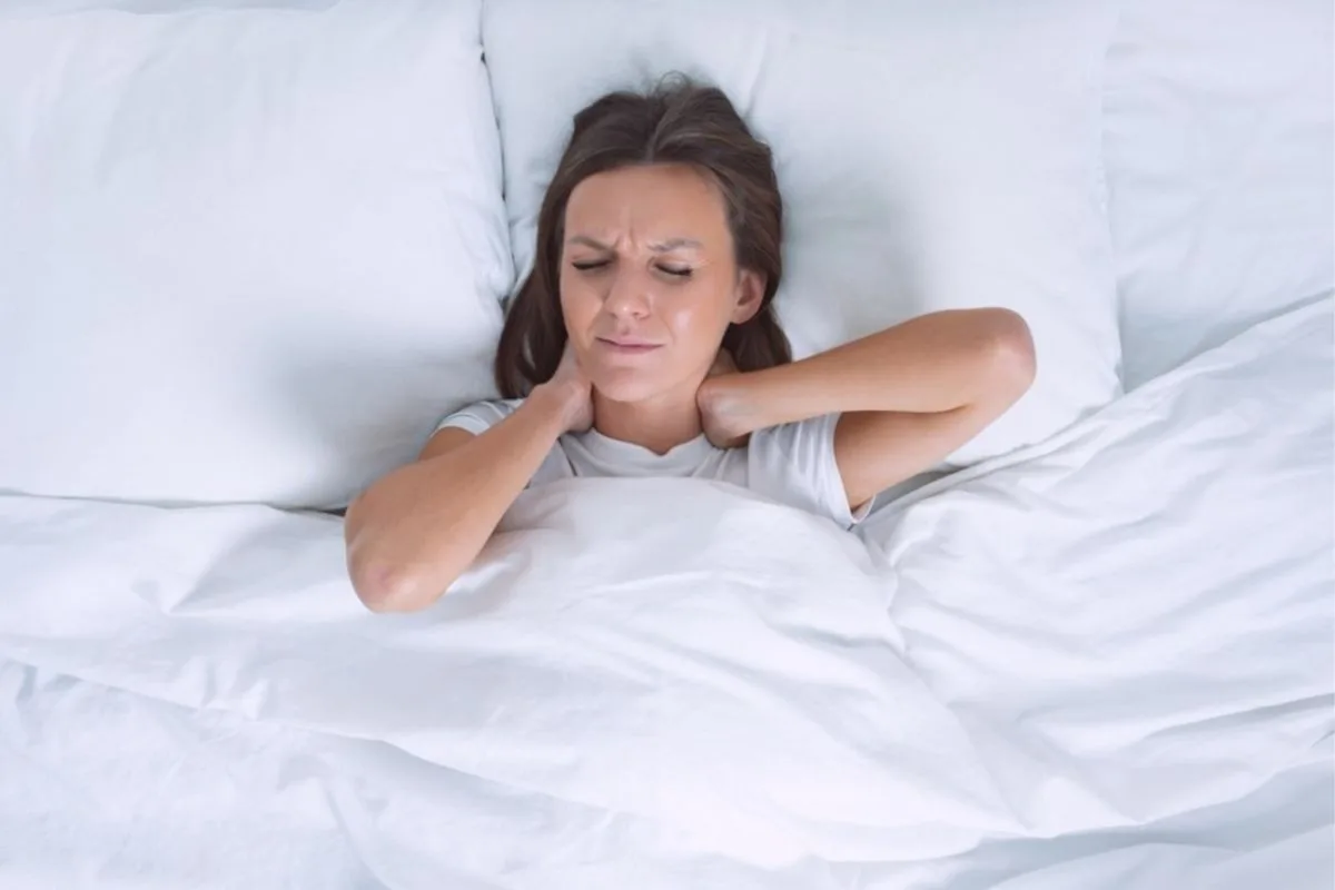 How High Should a Pillow Be for Side Sleepers? Side sleeper experiencing neck pain caused by a pillow with the wrong height and inadequate support