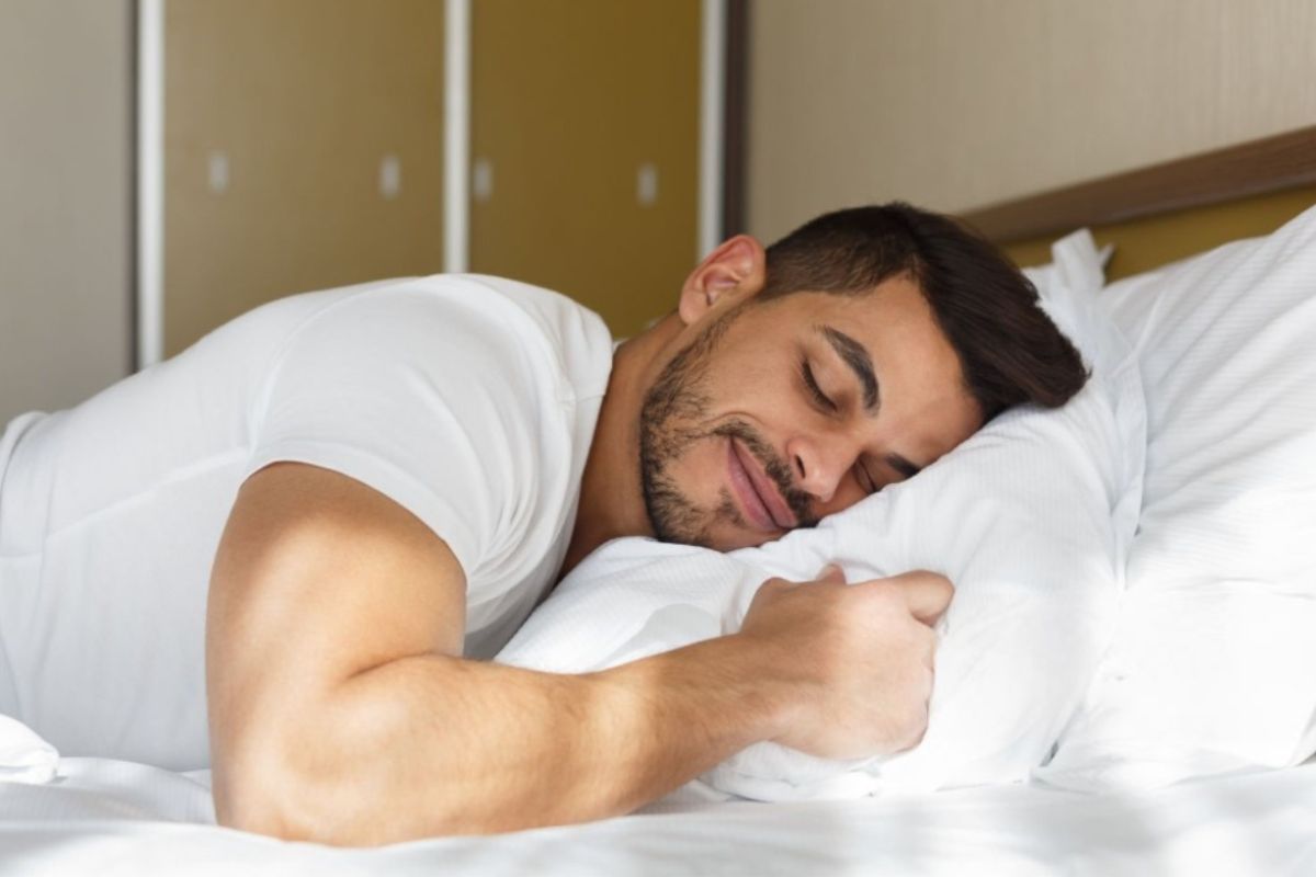 Man sleeping on his stomach with a supportive pillow to demonstrate proper stomach sleeping posture