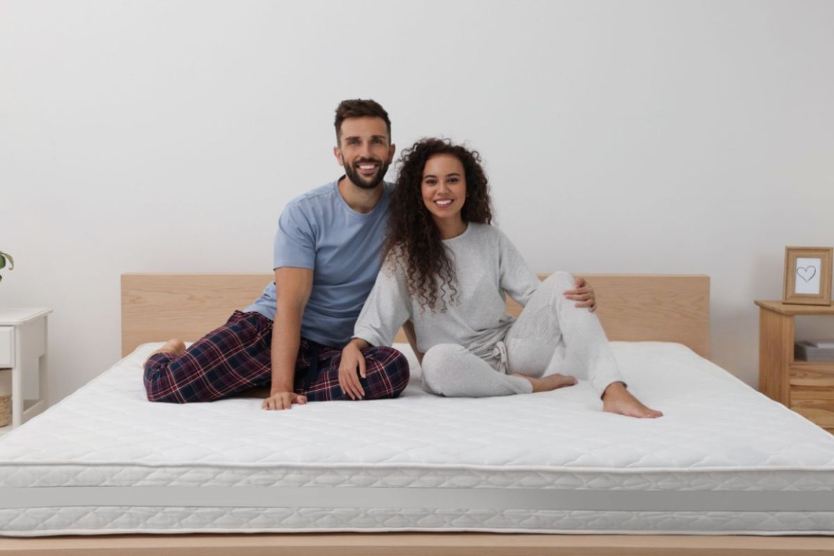 Is a Spring Mattress Good for Sex? Couple sitting on a spring mattress, illustrating edge support, responsiveness, and shared comfort for couples