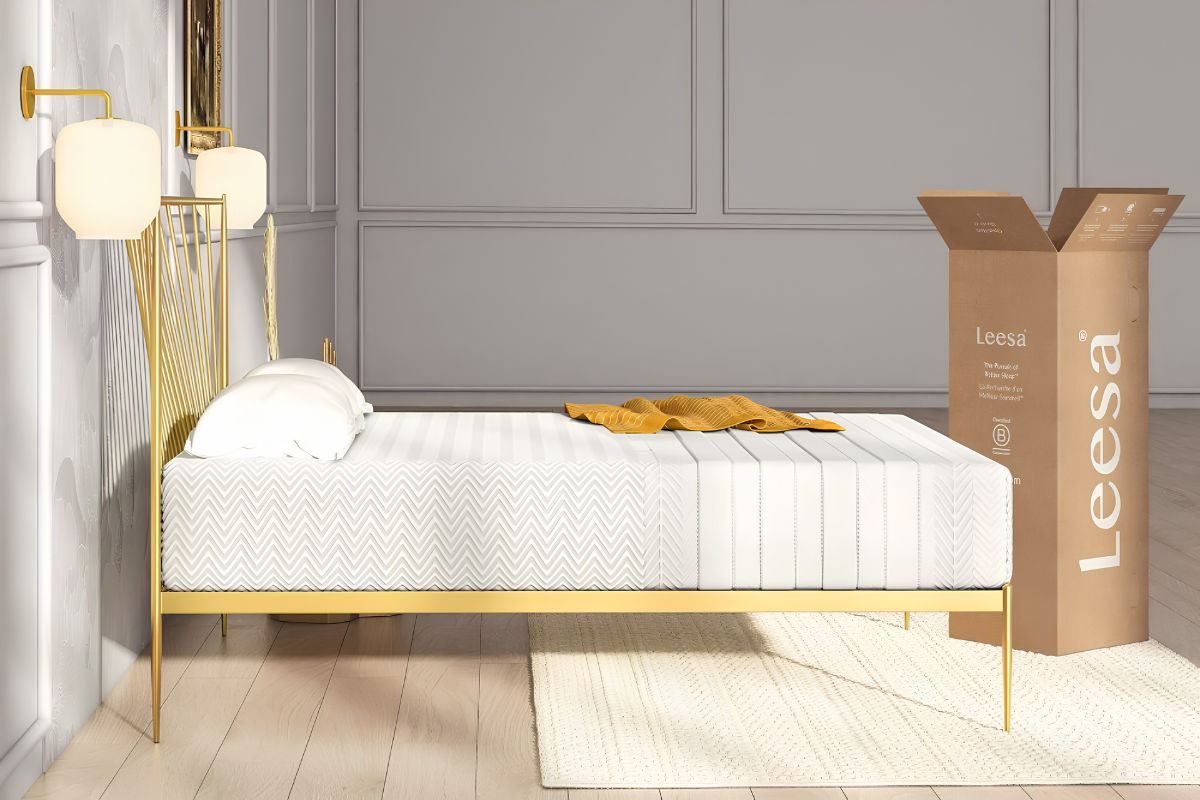 Leesa Legend Hybrid mattress positioned beside its shipping box, showing the mattress appearance and bed-in-a-box setup.