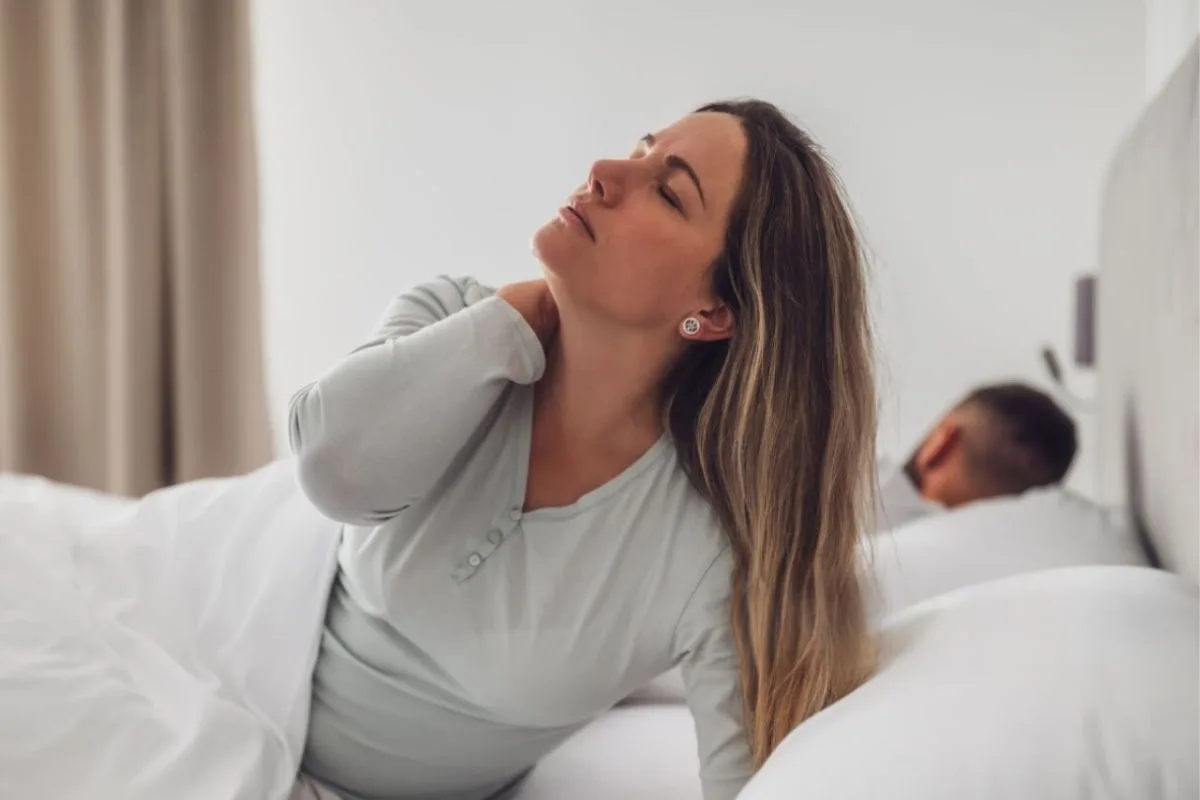 What’s the Best Pillow Firmness for Stomach Sleepers? Woman experiencing neck discomfort after sleep, highlighting how the wrong pillow firmness can affect stomach sleepers