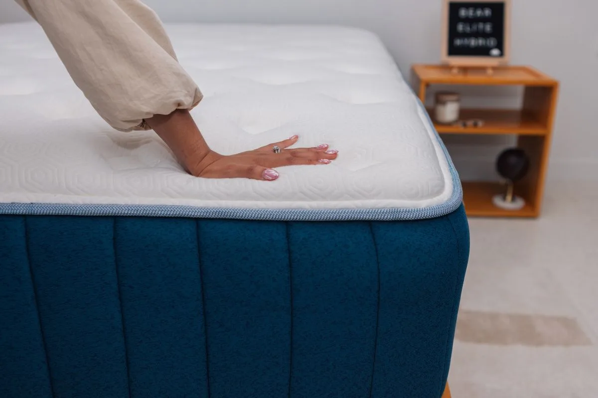 Close-up of the Bear Elite Hybrid mattress surface showing responsive cushioning and minimal sinkage under hand pressure