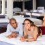 Couple testing a mattress in a showroom to evaluate comfort, support, and responsiveness for better sexual wellness and sleep quality