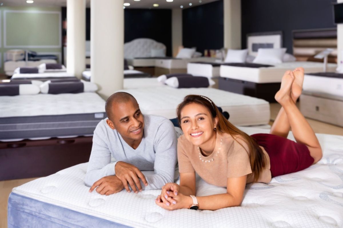 Couple testing a mattress in a showroom to evaluate comfort, support, and responsiveness for better sexual wellness and sleep quality