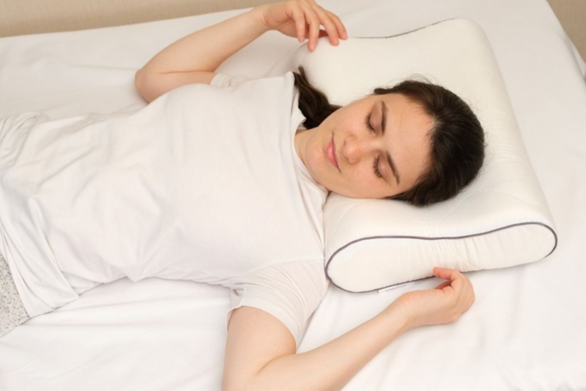 Back sleeper using a medium-loft pillow to maintain proper head, neck, and spinal alignment during sleep