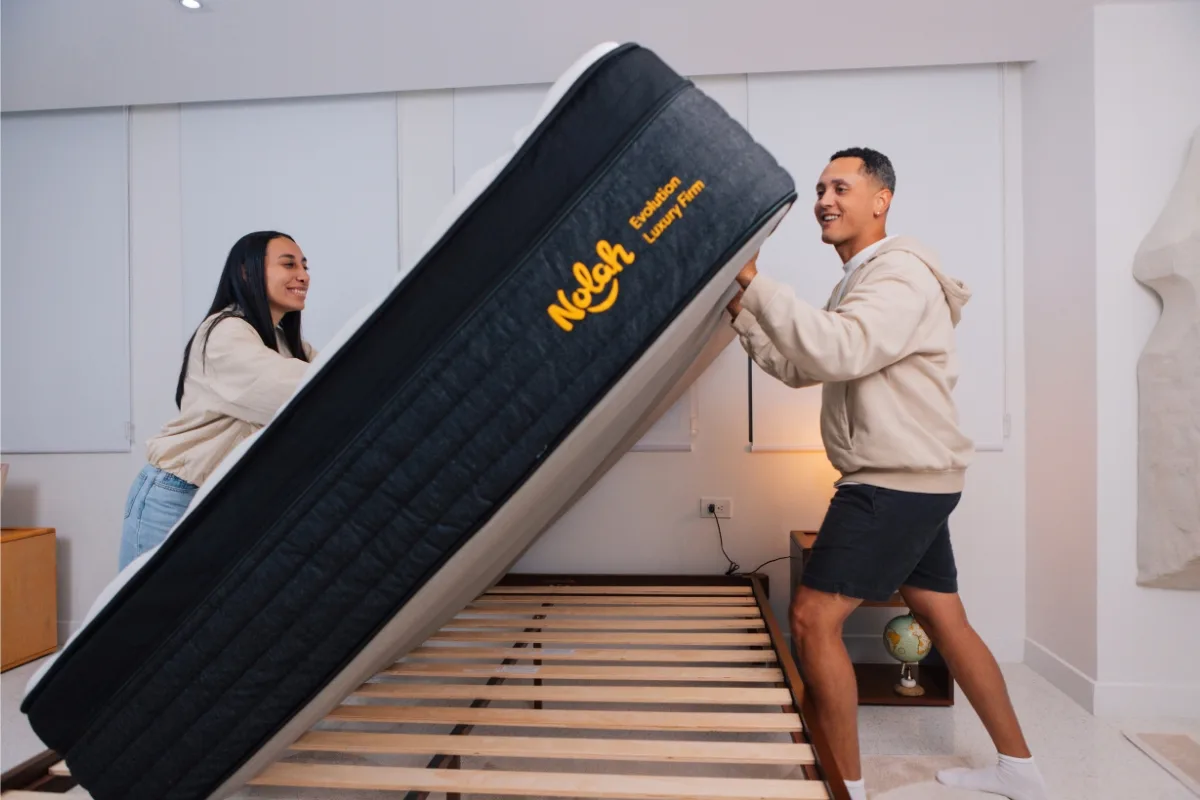Mattress Advisory testers placing a Nolah Evolution 15 mattress on a slatted foundation for compatibility testing.