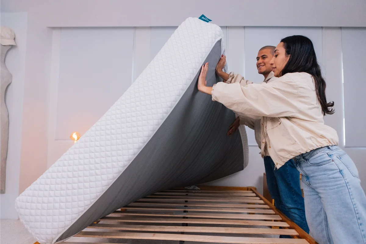 Mattress Advisory testers lifting a Leesa Sapira Hybrid Mattress to inspect its construction and foundation compatibility.