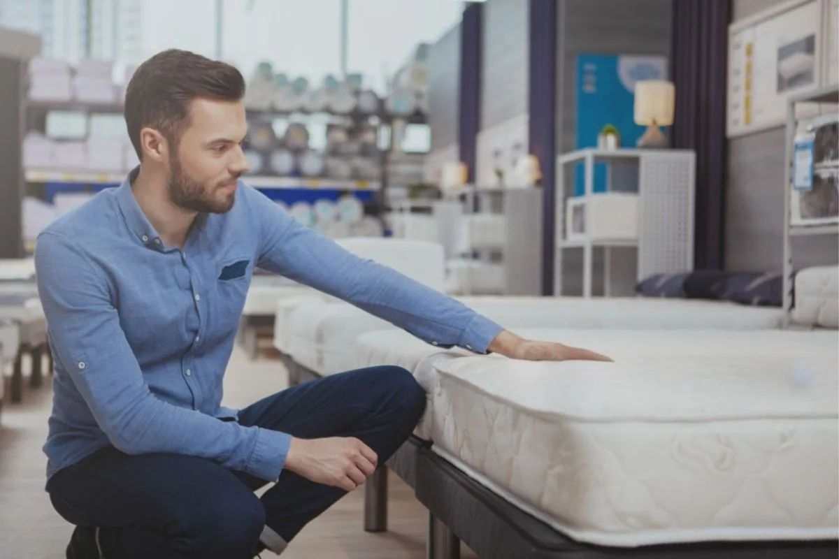 What Should Combination Sleepers Sleep On? Shopper testing a mattress in a showroom to find the best mattress for combination sleepers